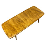 Load image into Gallery viewer, A mid-century modern wooden coffee table with a rounded rectangular top, featuring a rich warm brown wood grain finish and tapered legs, shown on a plain white background.
