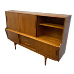 Load image into Gallery viewer, Mid-century modern wooden sideboard with a warm honey finish, featuring two cabinet doors, two drawers, open shelving, and tapered legs, shown on a plain white background.
