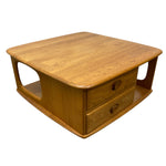 Load image into Gallery viewer, A mid-century modern wooden coffee table with two drawers, featuring a warm honey-toned wood finish and distinctive curved legs, isolated on a white background.
