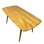 Load image into Gallery viewer, A mid-century modern wooden coffee table with a rounded rectangular top, natural wood grain, and tapered legs, shown on a plain white background.
