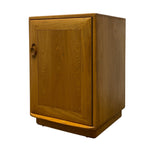 Load image into Gallery viewer, A mid-century modern wooden cabinet with a warm honey-toned finish, featuring a single paneled door with a round wooden pull handle, photographed on a solid white background.
