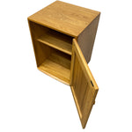 Load image into Gallery viewer, A light oak wood side cabinet with a single open door and two interior shelves, shown on a plain white background.
