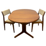 Load image into Gallery viewer, A mid-century modern dining set featuring an oval wooden table with a star base and two matching chairs with beige upholstered seats and backs, shown on a plain white background.

