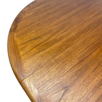 Load image into Gallery viewer, Close-up of a wooden table top showing a warm medium-brown wood grain finish and a curved edge with a visible joint.
