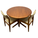 Load image into Gallery viewer, A mid-century modern round wooden dining table with two matching chairs featuring beige upholstered seats and backs, shown on a plain white background.
