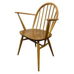 Load image into Gallery viewer, A mid-century modern wooden armchair with a spindle back, curved armrests, and angled legs, shown on a plain white background.
