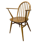 Load image into Gallery viewer, A mid-century modern wooden armchair with a spindle back, curved armrests, and tapered legs, shown on a plain white background.
