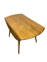 Load image into Gallery viewer, A mid-century modern wooden coffee table with a curved, boat-like top and tapered legs, shown from an elevated angle against a plain white background.
