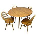 Load image into Gallery viewer, A mid-century modern wooden dining set consisting of a round table and four spindle-back chairs, shown against a plain white background.
