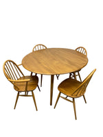 Load image into Gallery viewer, A mid-century modern wooden dining set consisting of a round table and four spindle-back chairs, shown against a plain white background.
