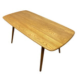 Load image into Gallery viewer, A mid-century modern wooden coffee table with a rounded rectangular top, featuring a warm honey-toned oak wood grain finish and tapered dark wood legs, shown on a plain white background.
