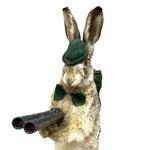 Load image into Gallery viewer, A taxidermy-style rabbit wearing a dark green felt hat and matching bow tie, holding a black double-barrel shotgun against a plain white background.
