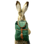 Load image into Gallery viewer, A small green felt backpack with brown trim and strap, shown from behind on a rabbit against a plain white background.
