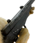 Load image into Gallery viewer, A close-up of a black ornate rifle or shotgun barrel with engraved scrollwork and the text 'MADE IN HUNGARY' on the side, held by tan fur against a plain white background.
