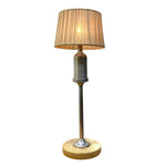 Load image into Gallery viewer, A vintage-style table lamp featuring a pleated beige fabric shade, a clear glass bulb holder with 'VINTA' printed on it, a polished silver metal stem, and a round light oak wood base.
