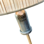 Load image into Gallery viewer, Close-up of a lamp base made from an Absolut Vodka glass, with a beige striped fabric shade and a brass-toned stem, on a white background.
