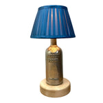 Load image into Gallery viewer, A decorative table lamp shaped like an Absolut Vodka bottle, with a blue pleated fabric shade on top and a round natural wood base, shown against a plain white background.
