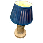 Load image into Gallery viewer, A table lamp featuring a blue pleated fabric shade, a natural wood cylindrical base, and a visible 'ABSOLUT VODKA' embossed on the wood, set against a plain white background.
