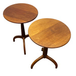 Load image into Gallery viewer, Two round wooden side tables with warm medium-brown wood grain, featuring pedestal bases with curved legs, shown on a plain white background.
