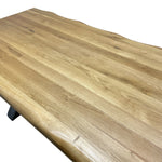 Load image into Gallery viewer, A close-up of a live-edge wooden tabletop with natural grain and a light tan finish, shown against a plain white background.
