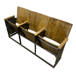 Load image into Gallery viewer, A vintage-style three-seat auditorium or theater bench with wooden backs and armrests on a dark metal frame, shown against a plain white background.
