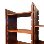 Load image into Gallery viewer, A close-up of a mid-century modern wooden bookshelf with distinctive interlocking dovetail-style side brackets and three shelves, shown against a solid white background.
