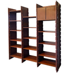 Load image into Gallery viewer, A mid-century modern wooden bookcase with three connected shelving units, featuring a warm reddish-brown wood finish and a top cabinet compartment, shown against a plain white background.
