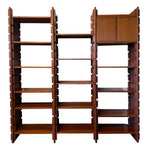 Load image into Gallery viewer, Mid-century modern wooden shelving unit with a warm reddish-brown finish, featuring multiple adjustable shelves, two cabinet doors on the top right, and a distinctive blocky geometric design.

