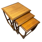 Load image into Gallery viewer, Three nested wooden nesting tables with a warm honey-toned finish and dark brown edges, shown on a plain white background.
