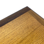 Load image into Gallery viewer, Close-up of a wooden board corner showing a two-tone wood grain finish with a dark brown border and a lighter golden-brown center, photographed on a white background.
