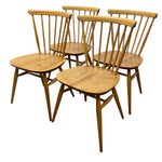 Load image into Gallery viewer, Four wooden spindle-back dining chairs with a warm medium-brown finish, arranged together on a plain white background.
