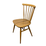 Load image into Gallery viewer, A mid-century modern wooden dining chair with a spindle back, rounded seat, and angled legs, shown on a plain white background.

