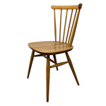 Load image into Gallery viewer, A mid-century modern wooden dining chair with a spindle back, rounded seat, and angled legs, shown against a plain white background.
