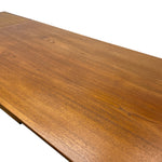 Load image into Gallery viewer, Close-up of a wooden tabletop with a warm medium-brown finish and visible wood grain, photographed against a plain white background.
