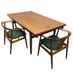 Load image into Gallery viewer, A mid-century modern wooden dining table set with two matching chairs featuring green upholstered seats, shown on a plain white background.
