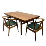 Load image into Gallery viewer, A mid-century modern wooden dining table with a rectangular wood top and four matching armchairs with curved wooden frames and green upholstered seats, shown on a plain white background.
