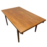 Load image into Gallery viewer, A mid-century modern rectangular wooden table with a warm medium-brown walnut finish and tapered legs, shown from an elevated angle on a white background.
