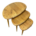 Load image into Gallery viewer, Three nested oval nesting tables made of natural oak wood with visible grain patterns and tapered legs, shown on a plain white background.

