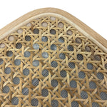 Load image into Gallery viewer, Close-up detail of a woven cane or rattan chair back with a light natural wood frame, showing the texture of the woven material and mesh backing on a white background.
