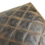 Load image into Gallery viewer, A close-up of a dark brown quilted leather surface with visible wear, scratches, and distressed texture against a white background.
