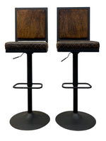 Load image into Gallery viewer, Two matching industrial-style bar stools with dark brown textured square backrests and diamond-quilted brown upholstered seats on black metal bases with footrests, shown against a plain white background.

