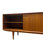Load image into Gallery viewer, A mid-century modern wooden sideboard cabinet with a warm medium-brown wood grain finish, featuring an open shelf compartment on the left and a closed door with a small metal pull handle on the right, shown against a plain white background.

