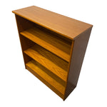 Load image into Gallery viewer, A mid-century modern wooden bookcase with three open shelves, featuring a warm honey-amber finish and visible wood grain patterns.
