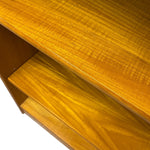 Load image into Gallery viewer, Close-up of a warm honey-toned wood surface with visible grain, showing part of a shelf or cabinet edge against a white background.
