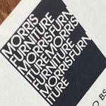 Load image into Gallery viewer, A close-up of a black and white Morris Furniture logo print, showing the brand name repeated in white text inside a black block on a light background.
