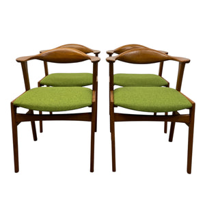 Four wooden chairs with green cushioned seats on a white background