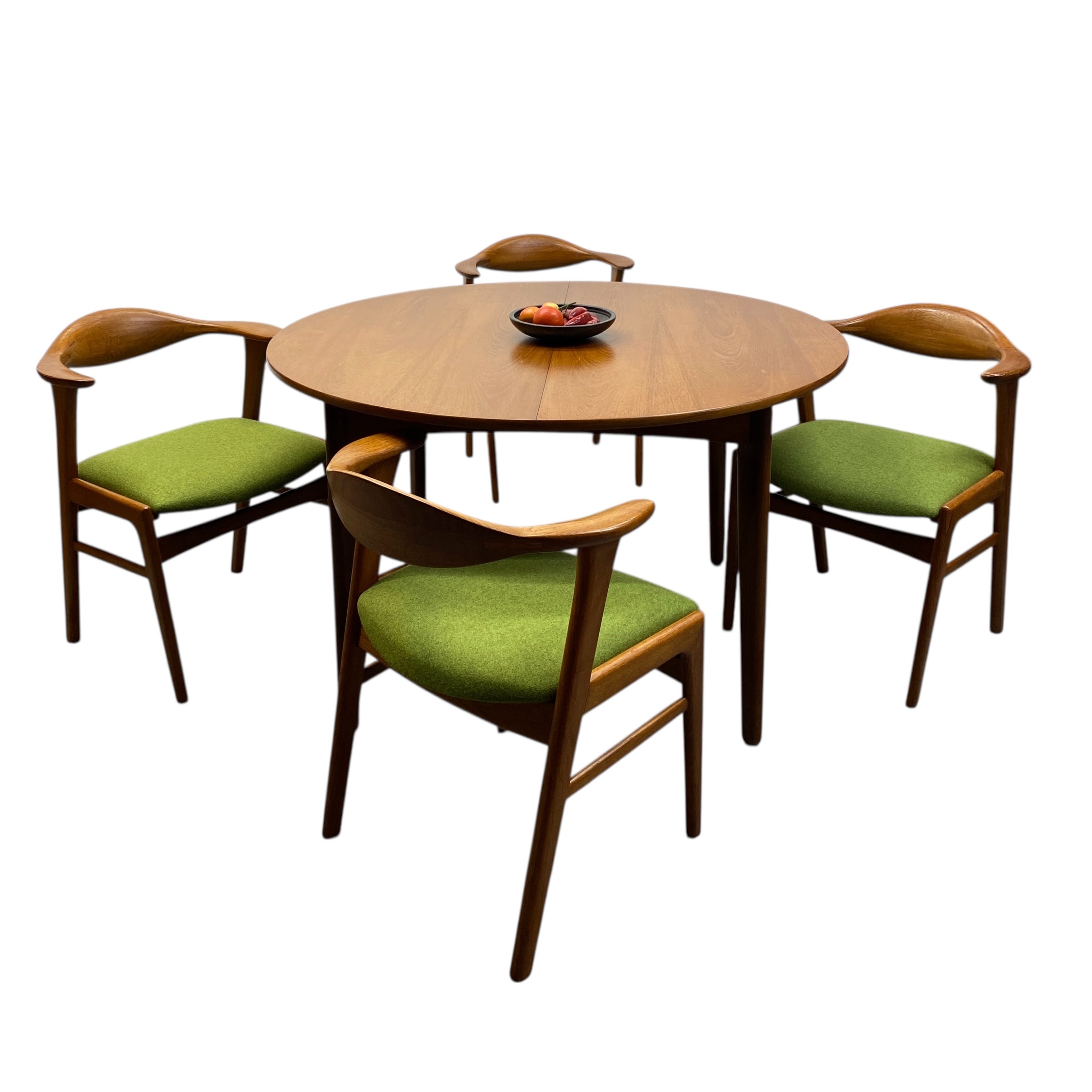 Round wooden table with four matching chairs featuring green cushions on a white background