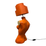 Load image into Gallery viewer, Orange lamp shaped like the back of a torso with a lampshade on a white background
