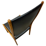 Load image into Gallery viewer, Black leather chair with wooden frame on a white background
