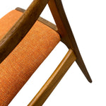 Load image into Gallery viewer, Close-up of an orange upholstered chair with wooden legs on a white background
